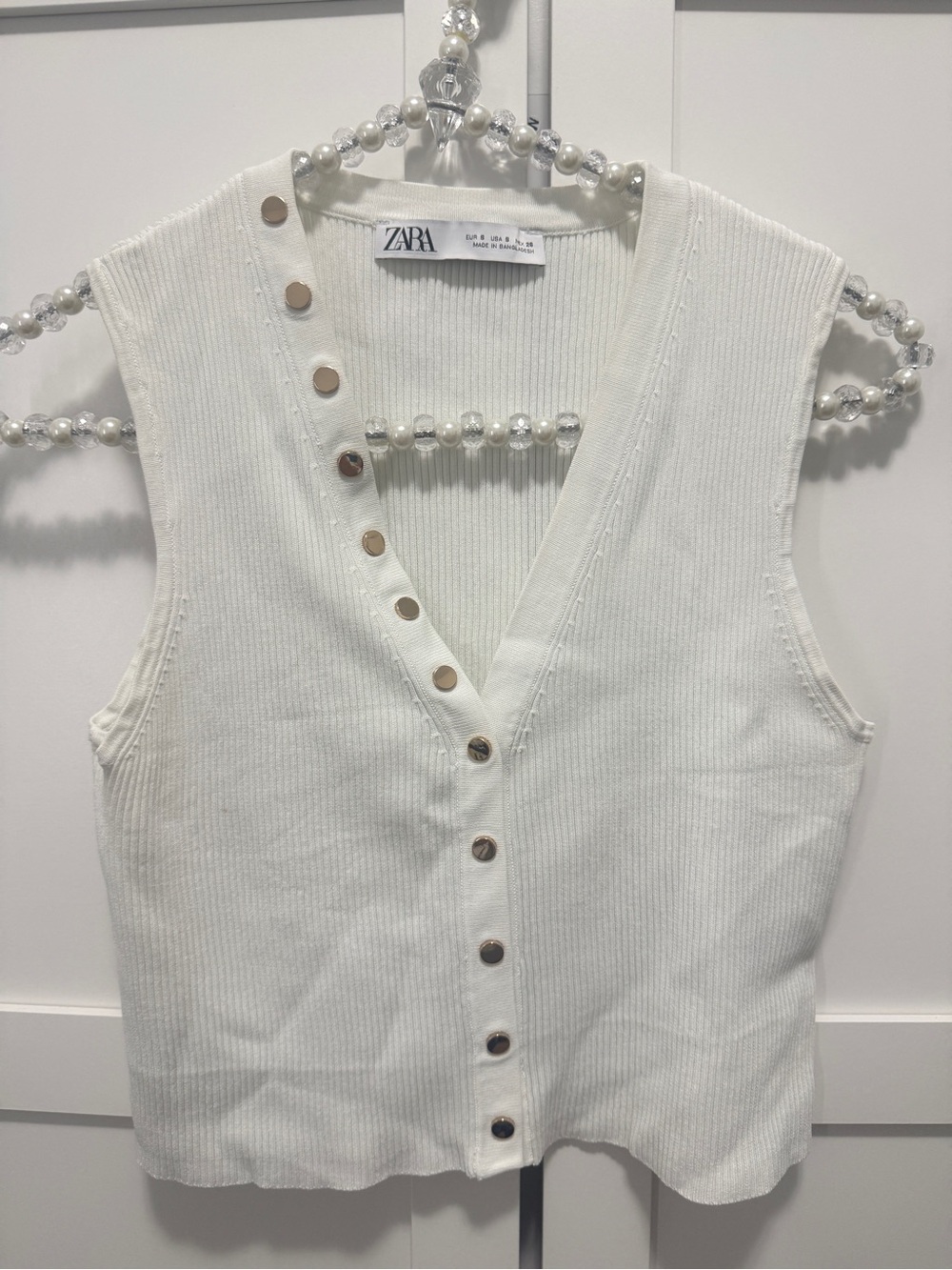Zara sleeveless ribbed knit top with V-neckline and gold-tone button details.